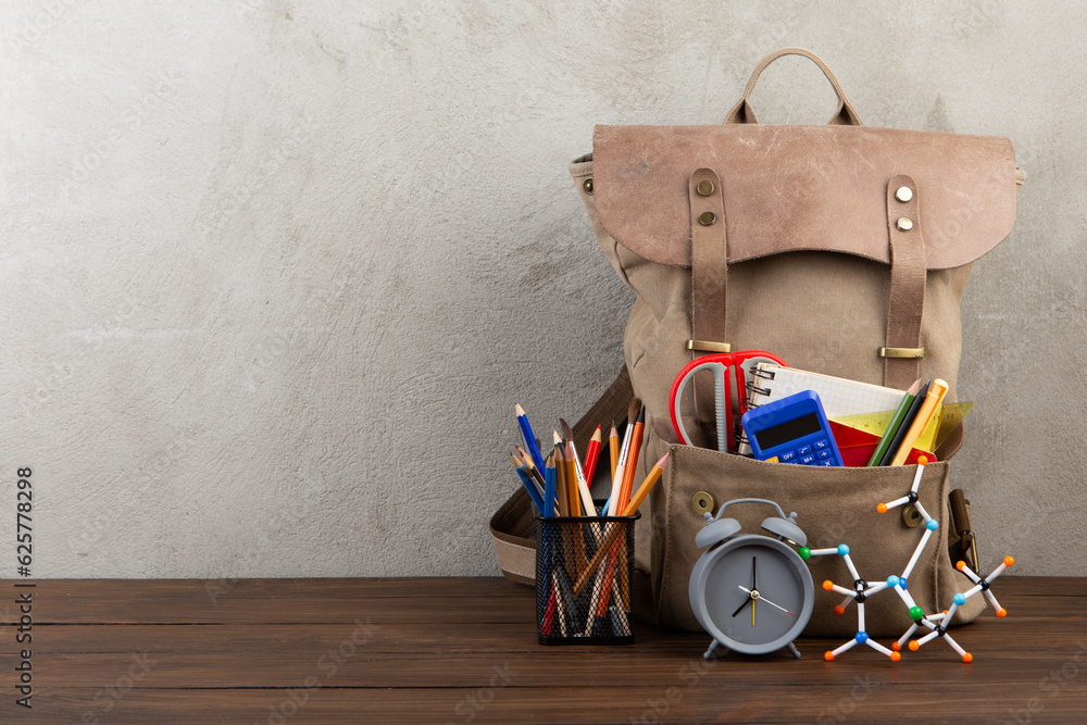 Back to school - books and school backpack on the desk in the auditorium, Education concept.