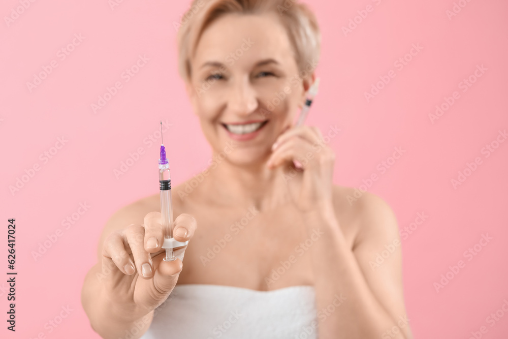 Mature woman with filler injections on pink background, closeup