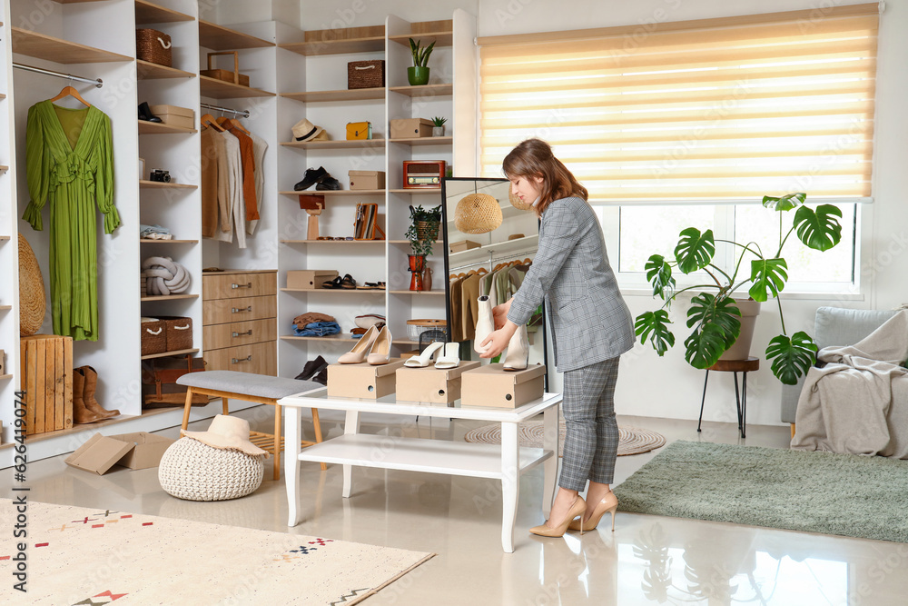 Young woman choosing shoes in light boutique