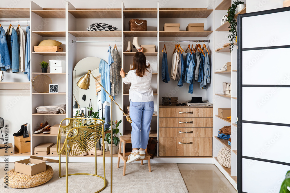 Young woman choosing shoes in light boutique