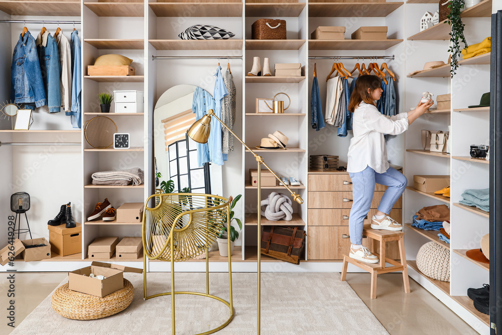 Young woman choosing shoes in light boutique