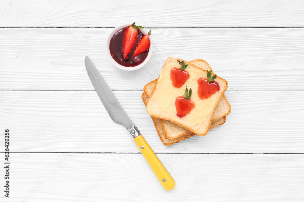 Tasty toasts with sweet strawberry jam on white wooden background