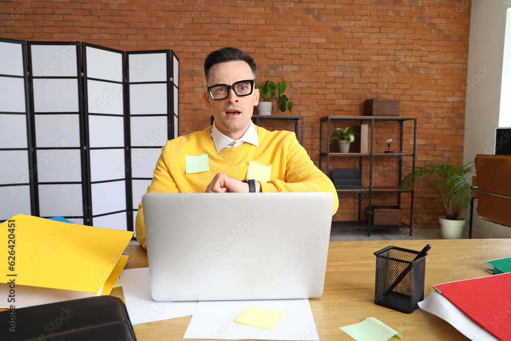 Stressed businessman working under deadline in office