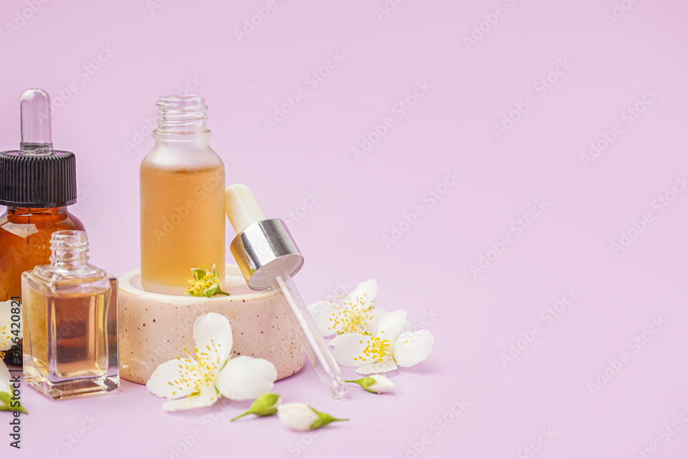 Composition with bottles of essential oil and beautiful jasmine flowers on lilac background