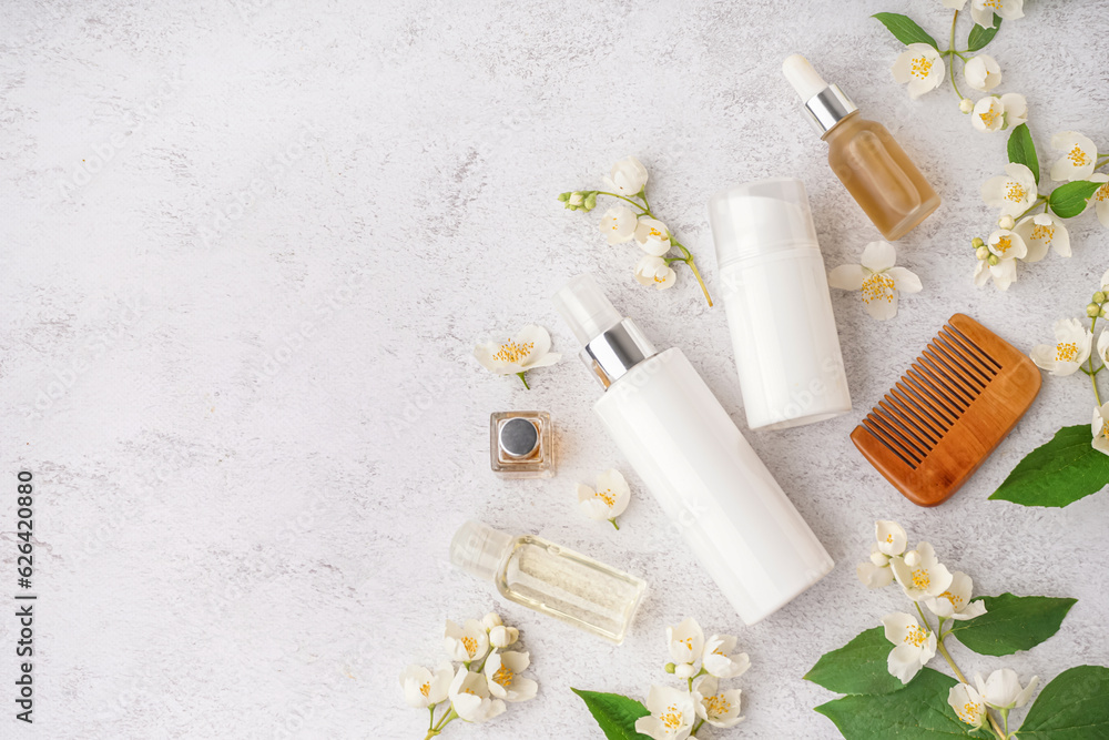 Composition with cosmetic products, hair comb and beautiful jasmine flowers on light background