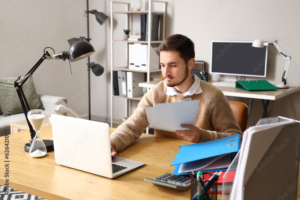 Young man working under deadline in office