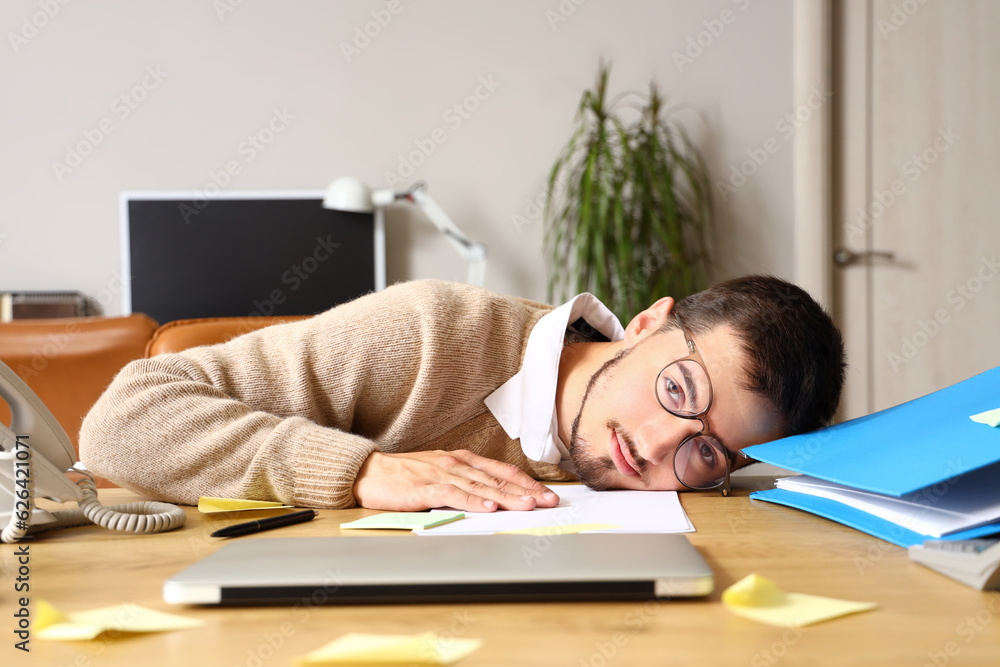 Stressed young man working under deadline in office