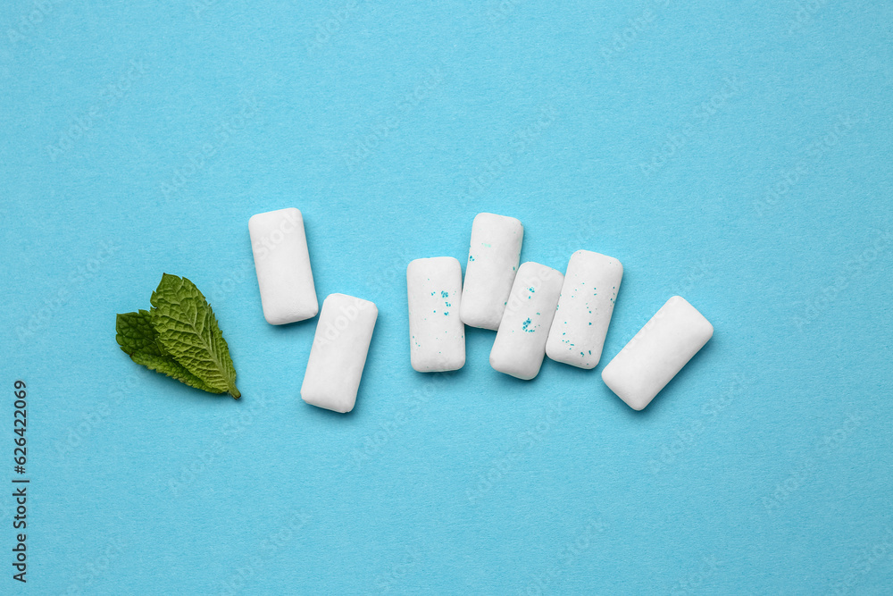 Fresh chewing gums with mint on blue background