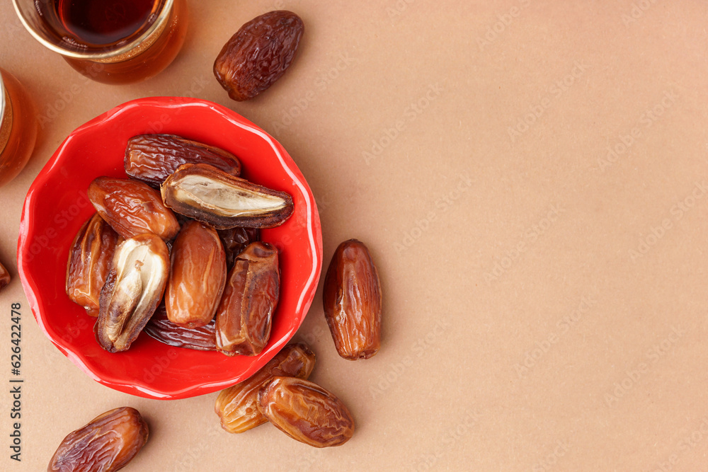 Bowl with dried dates on brown background