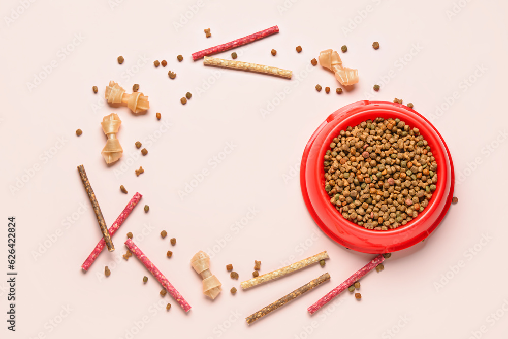 Frame made of dry dog food and treats on light background