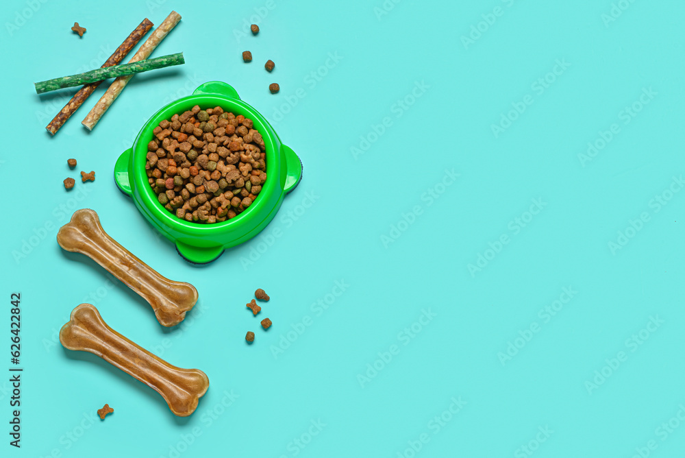 Composition with dog treats and dry food on color background