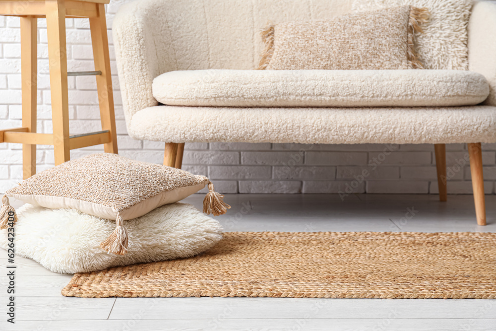 Wicker carpet with cushions in interior of living room, closeup