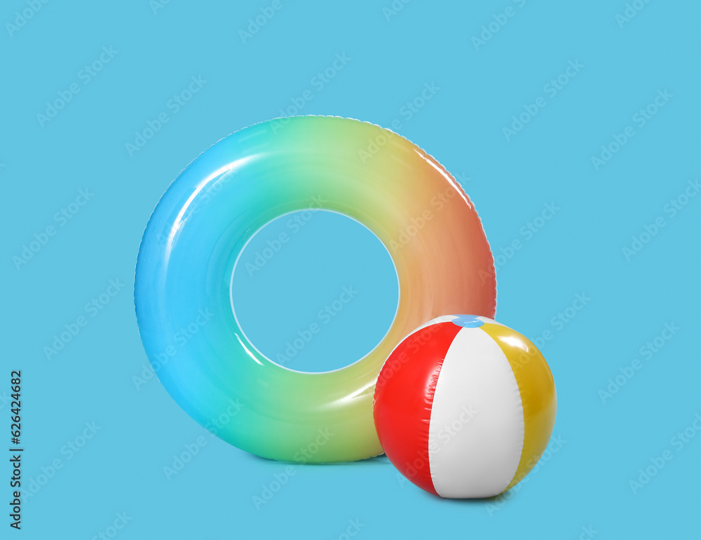 Inflatable beach ball and ring on blue background