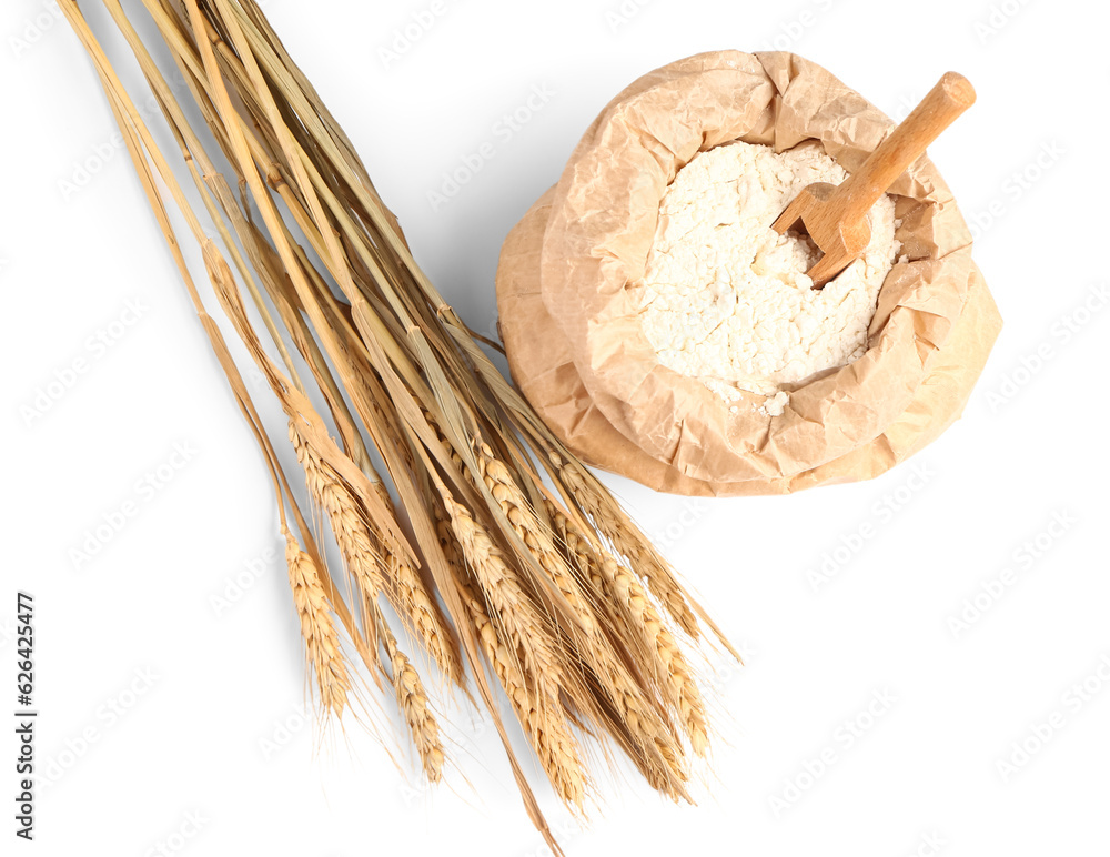 Paper bag with flour and wheat ears on white background