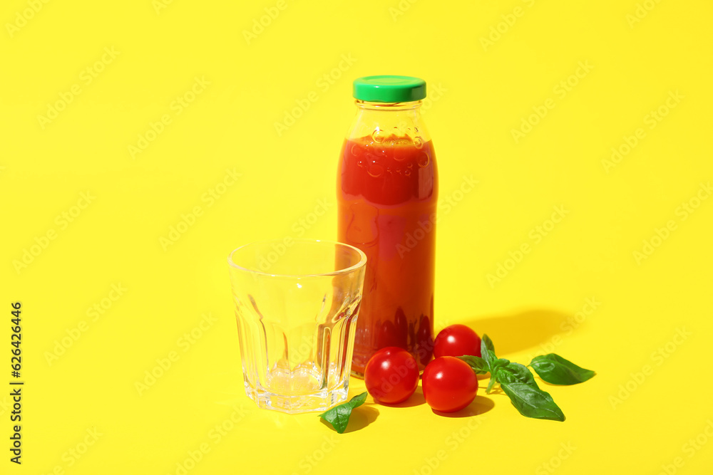 Empty glass and bottle of tasty tomato juice on yellow background