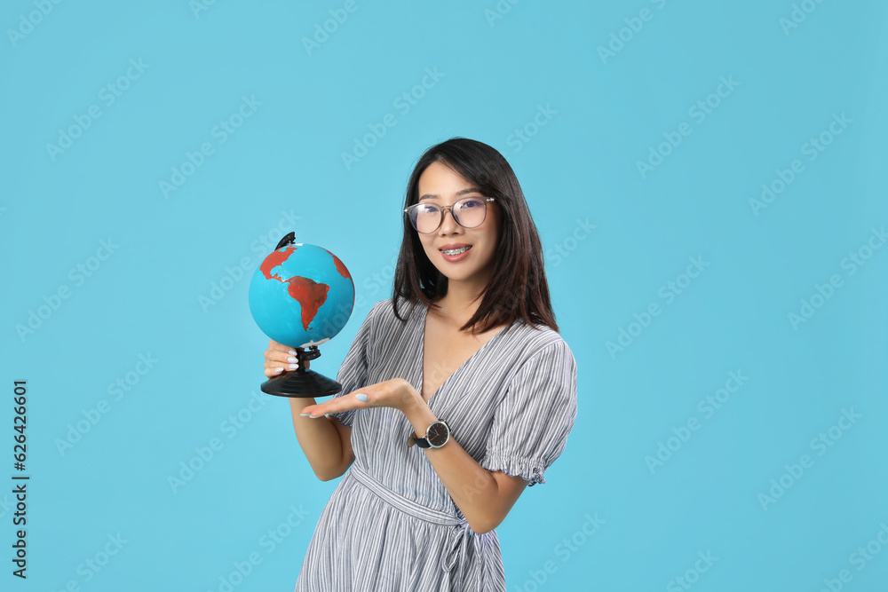 Asian Geography teacher with globe on blue background