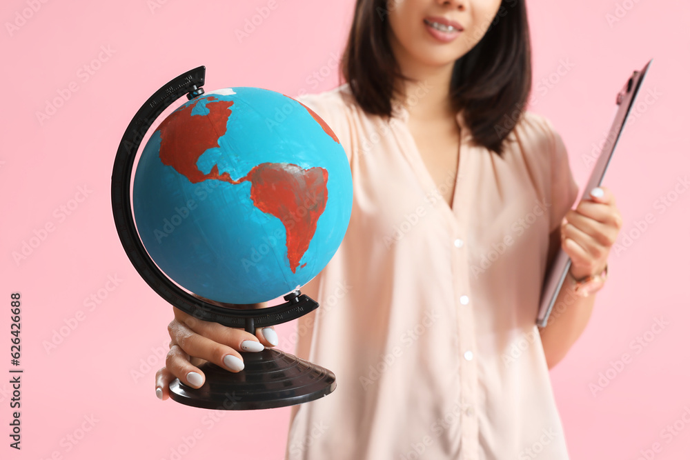 Asian Geography teacher with globe on pink background, closeup