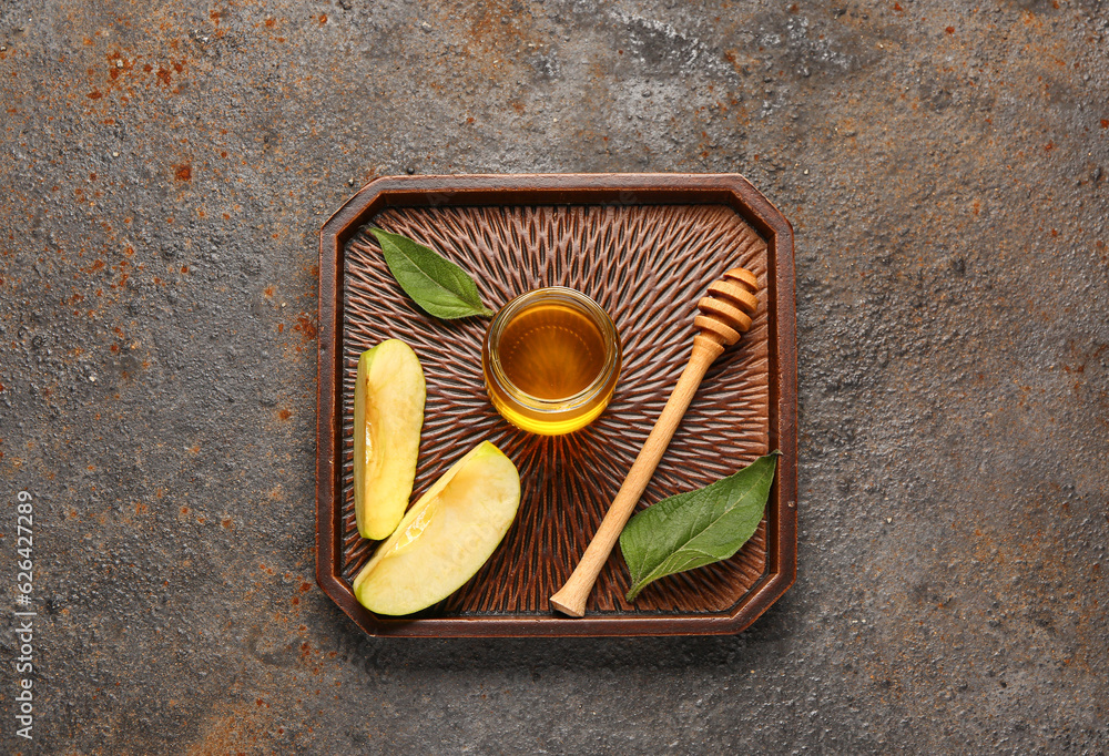 Tray with jar of sweet honey, apple and walnut on dark background