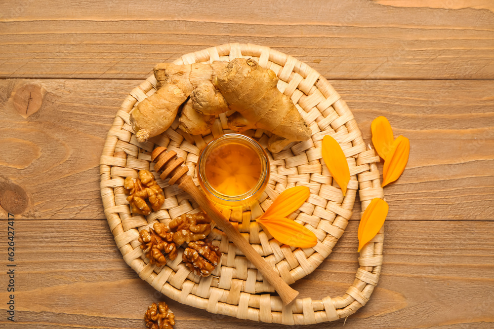 Jar of sweet honey with walnut and ginger on wooden background