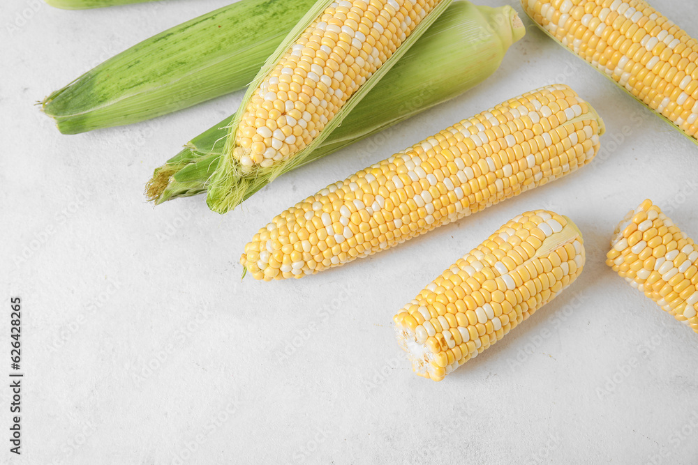 Fresh corn cobs on light background