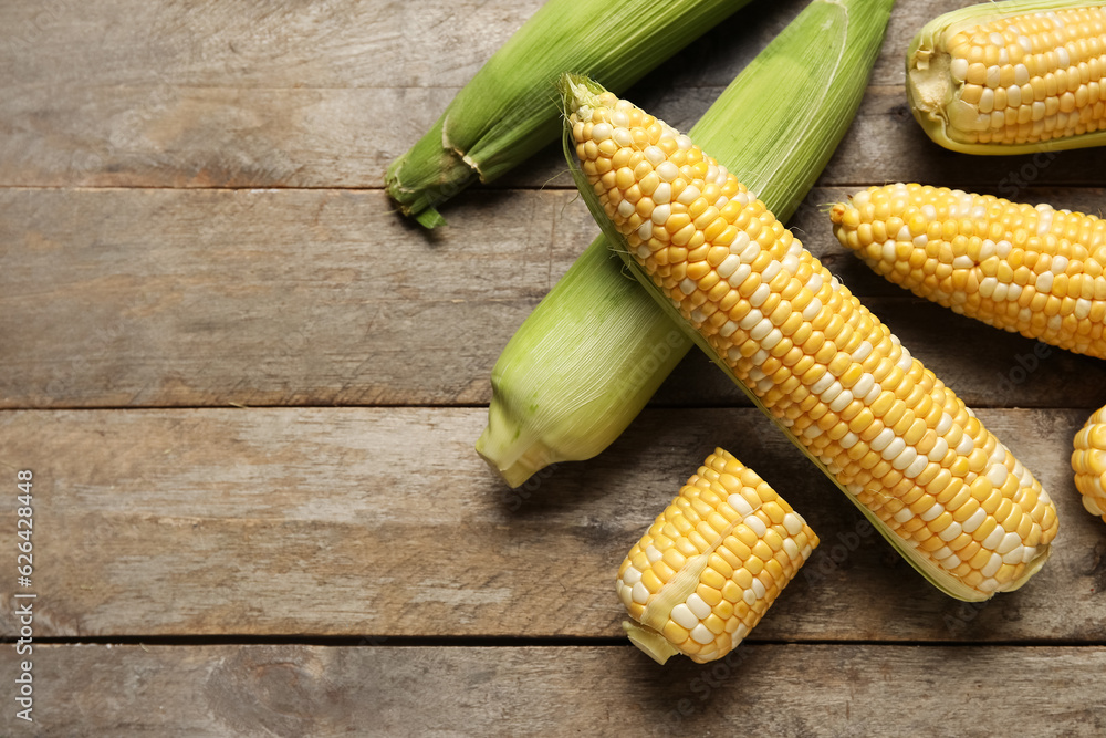 Fresh corn cobs on wooden background