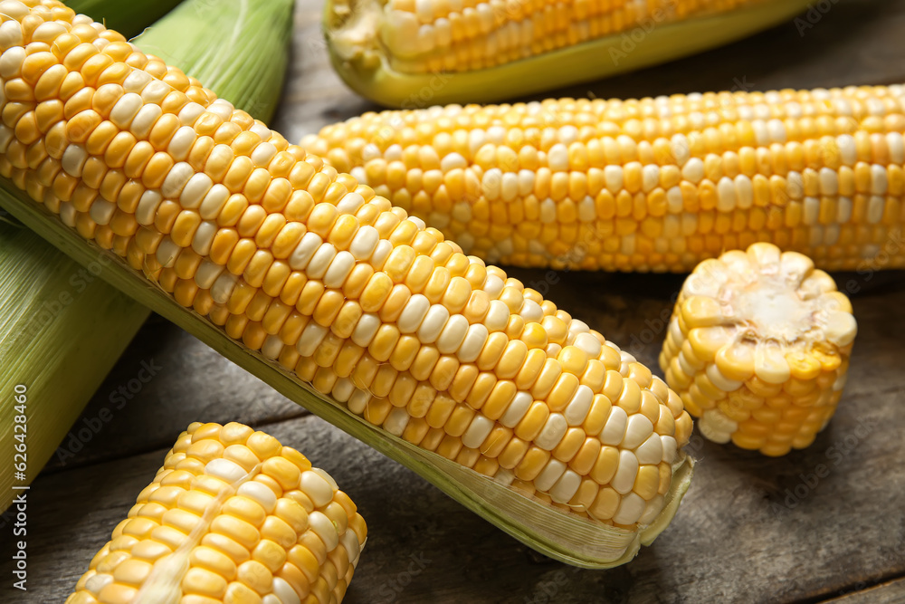 Fresh corn cobs on wooden background