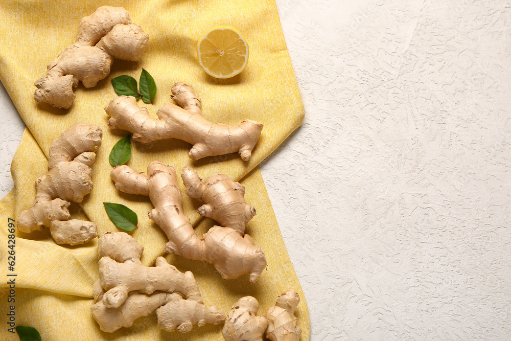 Fresh ginger roots with leaves and half of lemon on white background