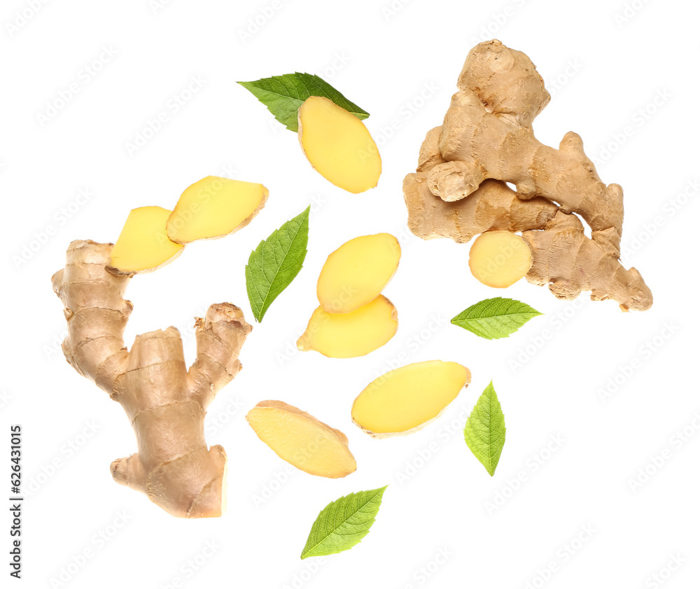 Flying slices of fresh ginger roots and leaves on white background