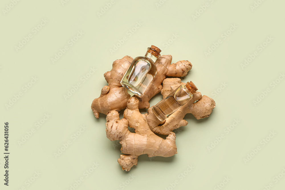 Bottles of ginger cosmetic oil on green background