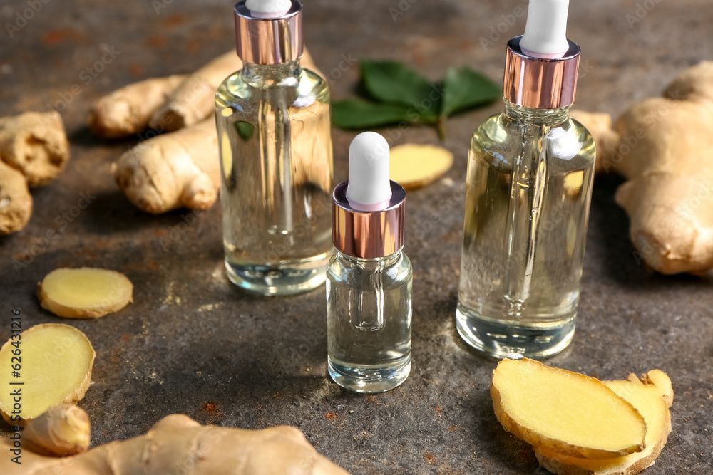 Bottles of ginger cosmetic oil on dark background