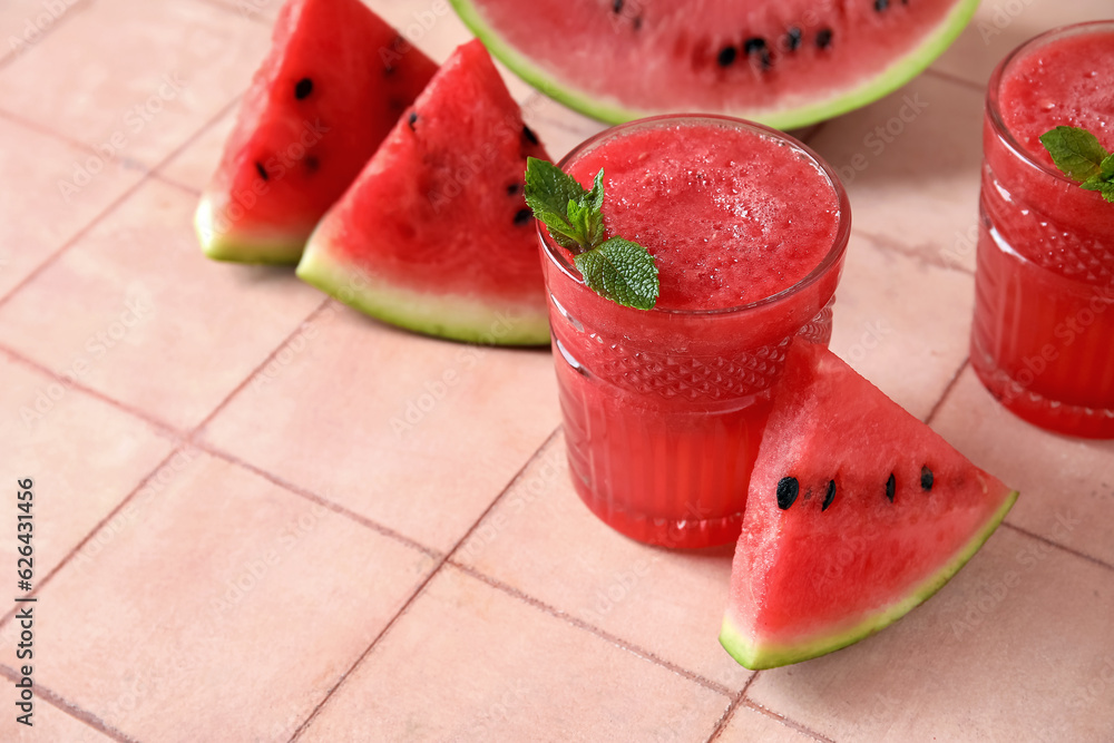 Glasses of tasty watermelon juice with mint on pink tile table