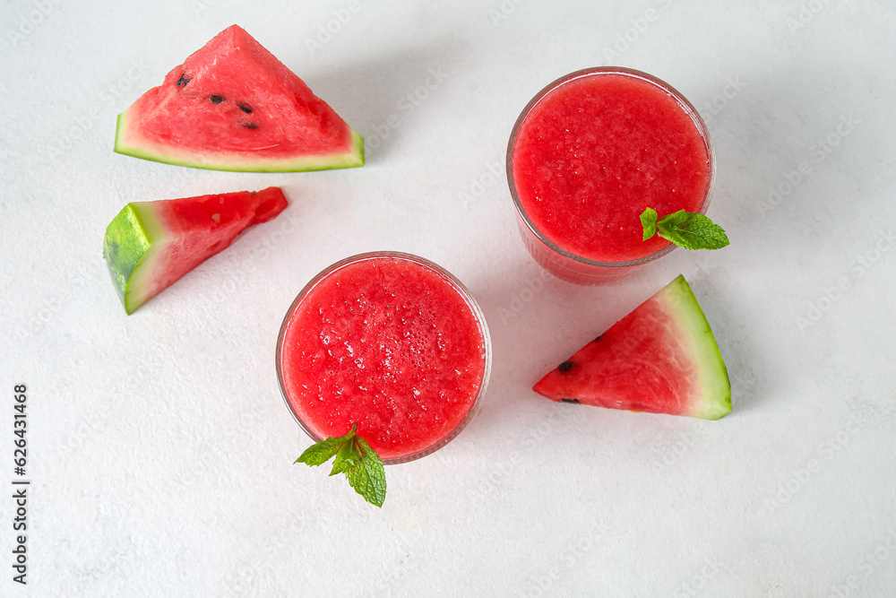 Glasses of tasty watermelon juice with mint on white table