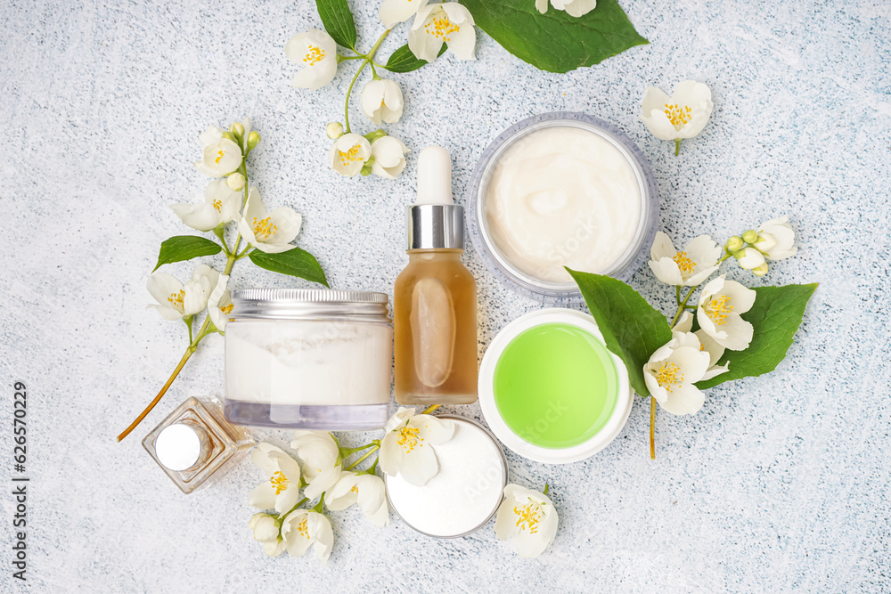 Composition with different cosmetic products and beautiful jasmine flowers on light background