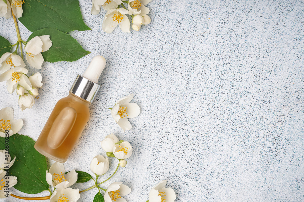 Composition with bottle of essential oil and jasmine flowers on light background