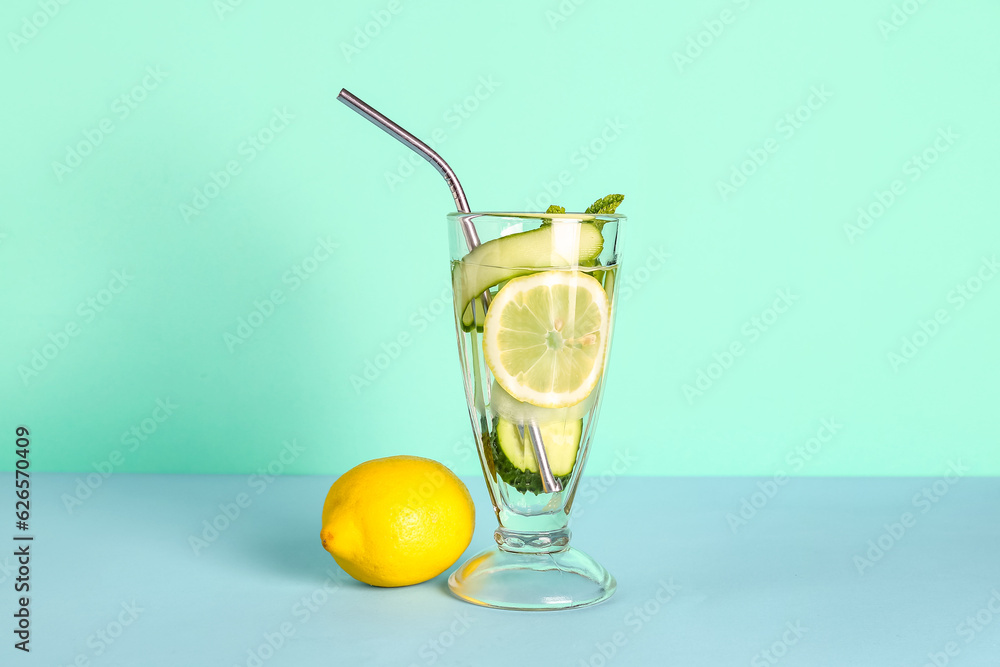 Glass of lemonade with cucumber and mint on blue background