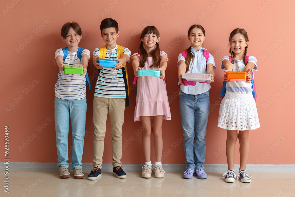 Little pupils with lunchboxes and backpacks near pink wall