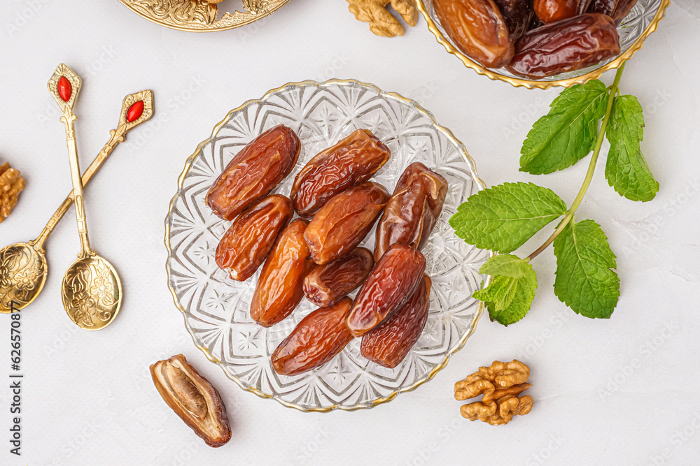 Bowls with dried dates on light background