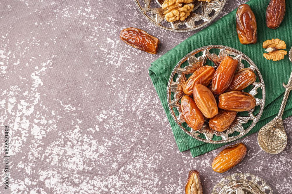 Bowl with dried dates on grey background