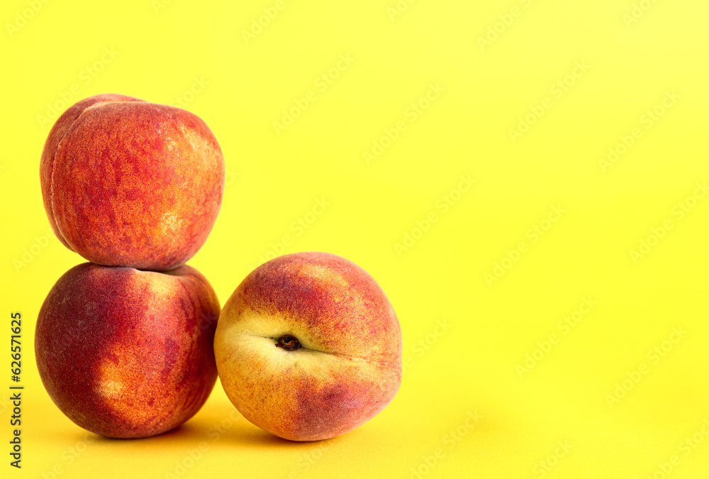 Sweet peaches on yellow background