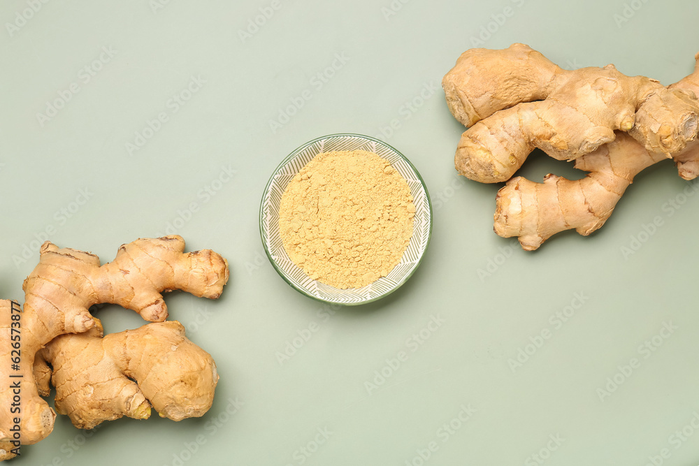 Fresh ginger roots and bowl with dried powder on grey background