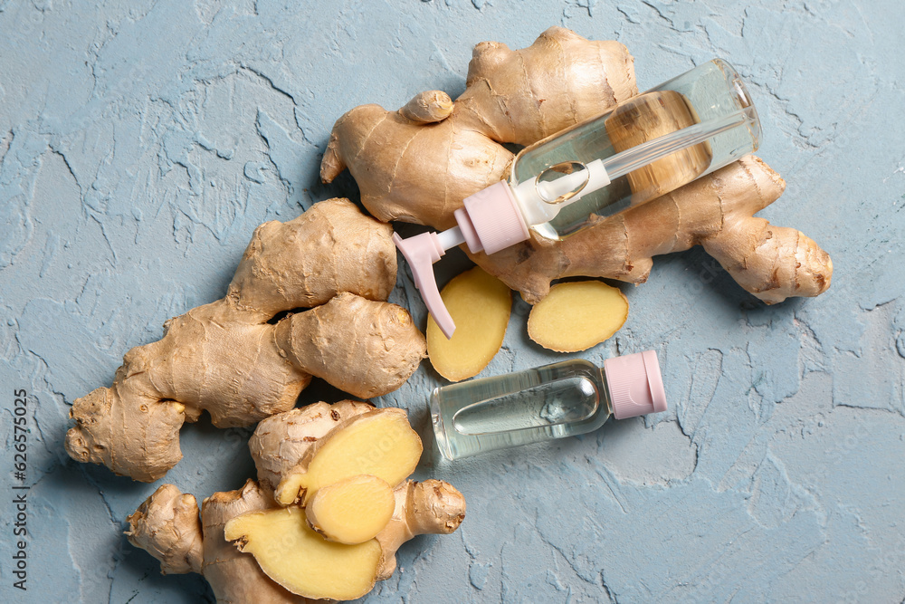 Bottles of ginger cosmetic oil on blue background