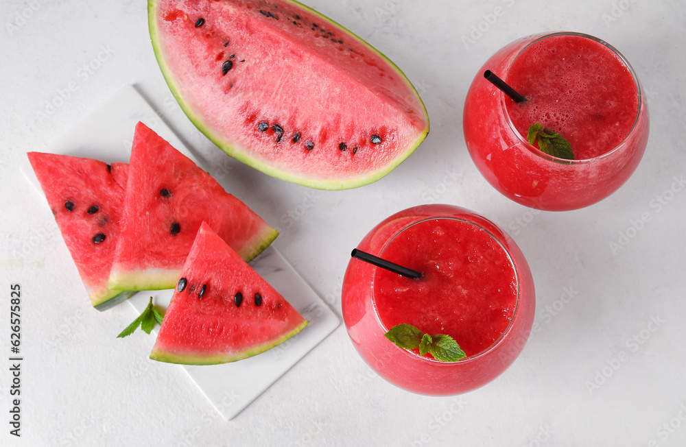 Glasses of tasty watermelon juice with mint on white background