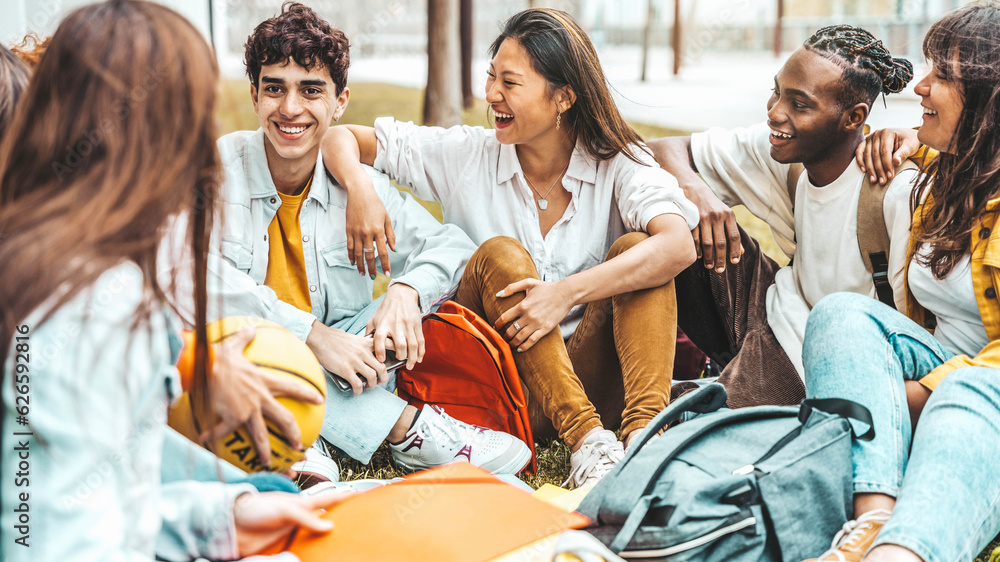 University students talking and laughing together in college campus - Happy teenagers having fun goi