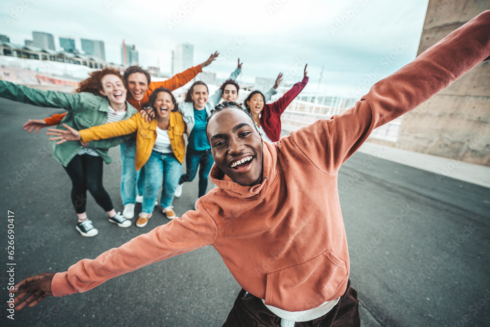 Group of young people laughing together at camera outdoors - Youth community life style concept with