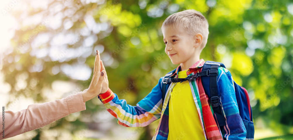 Mother giving a five to her son before starting a new year in school.