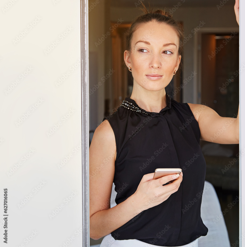 Waiting for an important text. Shot of a young woman using her cellphone in her hotel room.