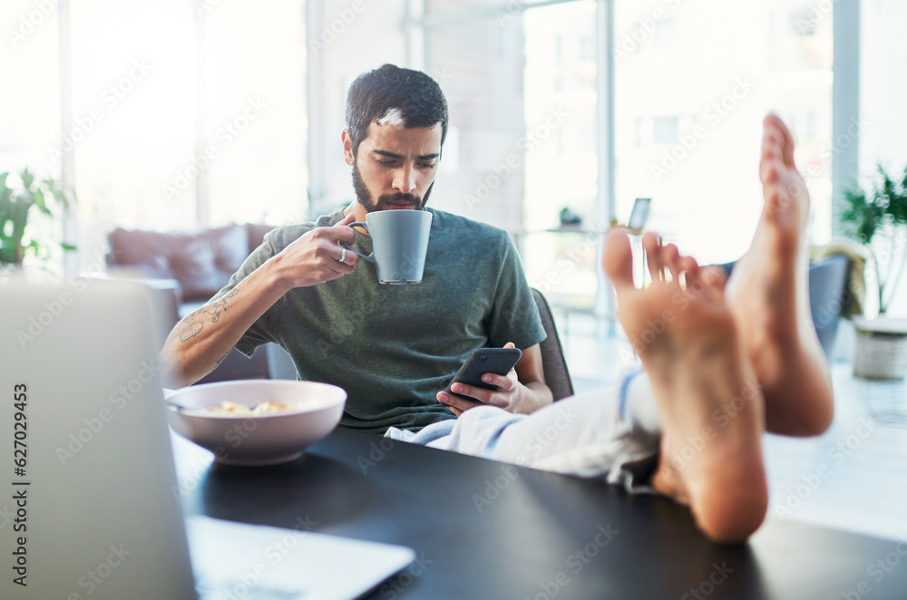 I have a lot in my feed. Shot of a man using his cellphone while having breakfast at home.