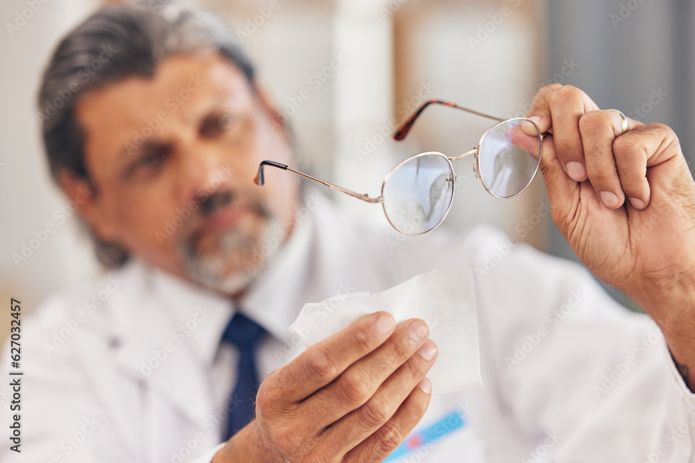 Hands, medical and an optometrist cleaning glasses in his office for vision, eyesight or hygiene. He