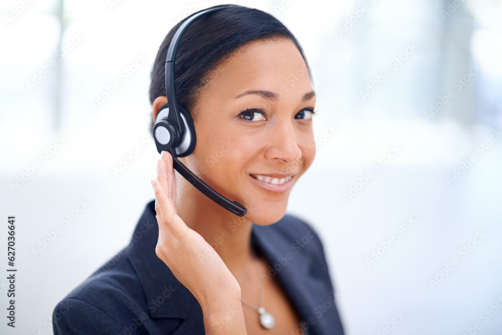 Service with a smile. An attractive call centre operator smiling at the camera.