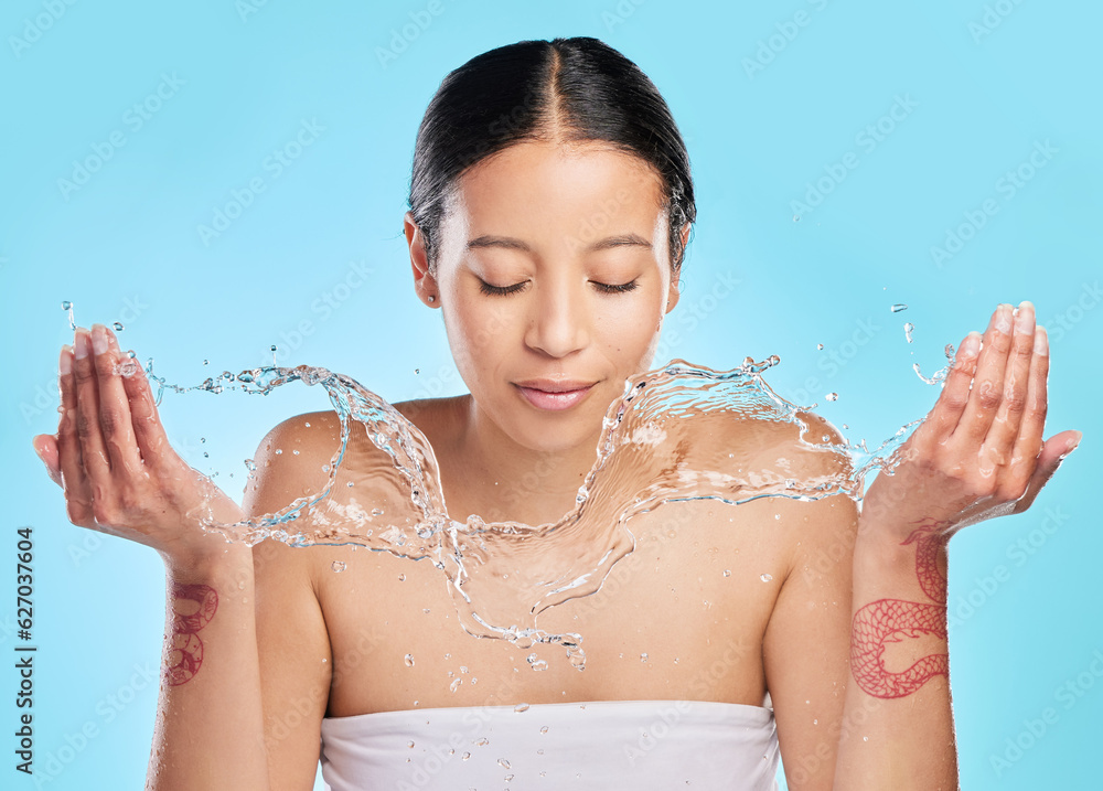 Washing, water and face of woman on blue background for wellness, healthy skin and cleaning in studi